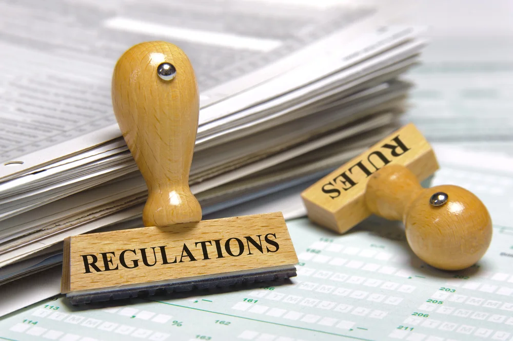 Regulatory advisors reviewing legal and compliance documentation in a meeting room.